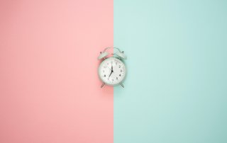 alarm clock on pink and turquoise background